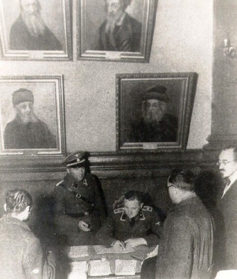German SS officers confiscating archive documents and property of the Jewish community from the Judenrat offices in the Warsaw ghetto.